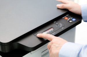 printing tips in the office Hand press button on panel of printer. printer scanner laser office copy machine supplies start concept
